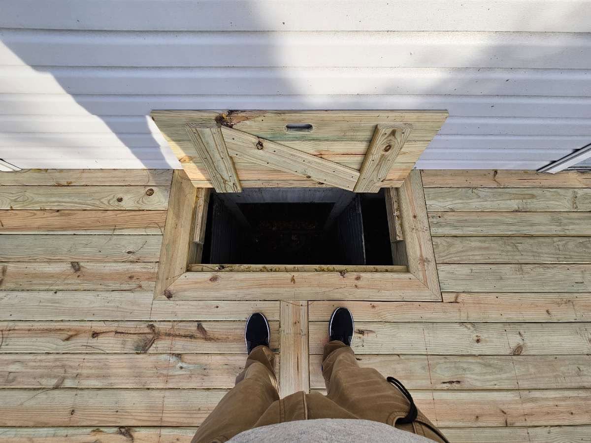 Deck access hatch opened to a crawlspace below new decking