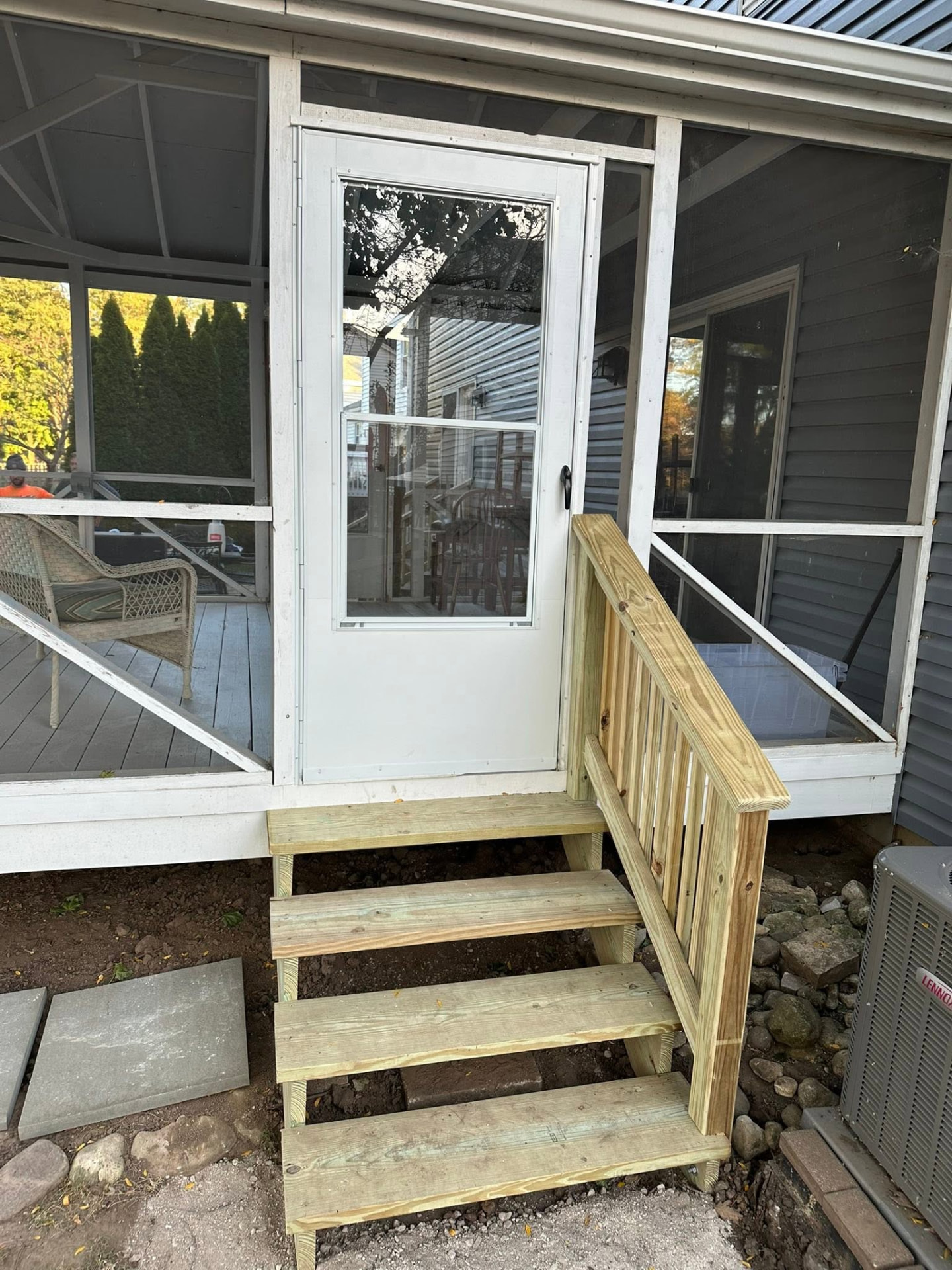 New wood steps and railing built at a screened porch entry