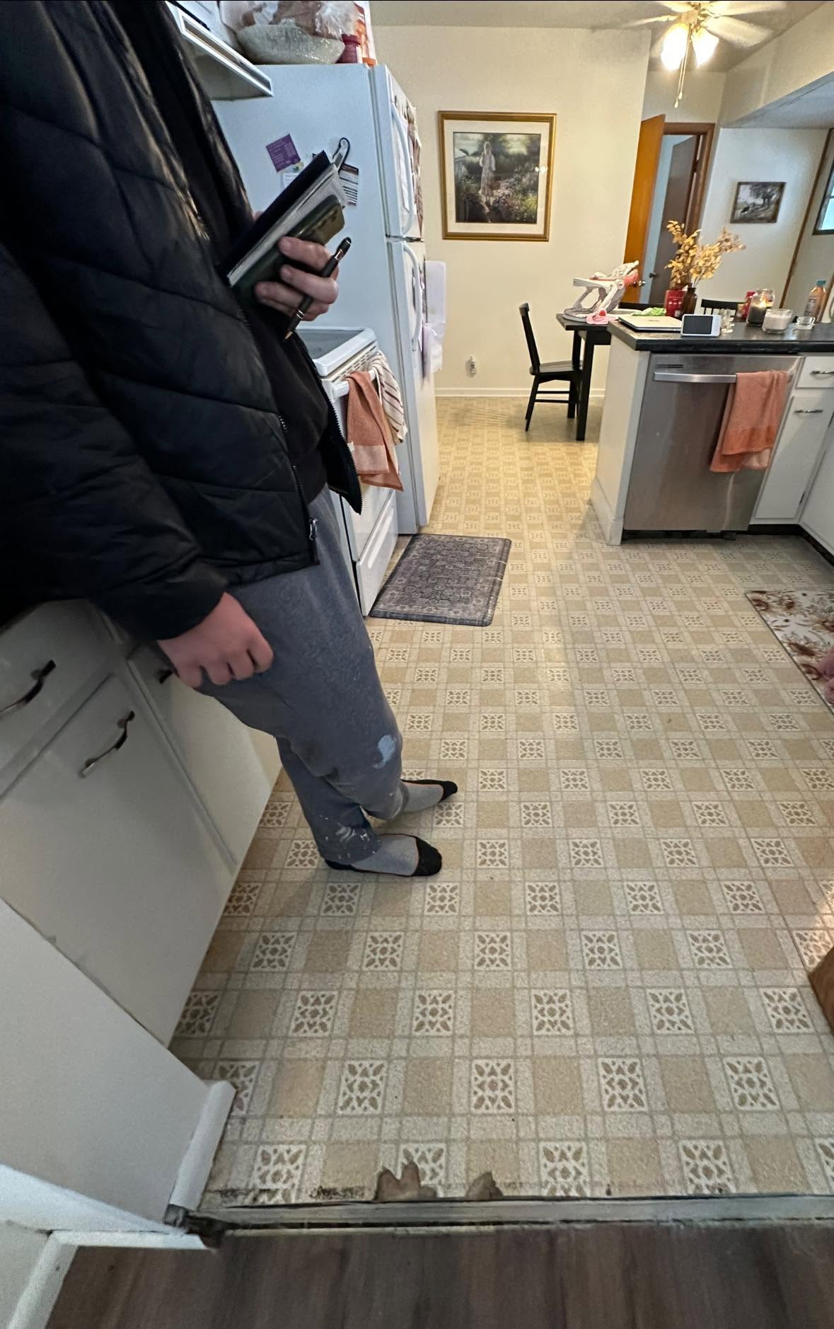Dated kitchen with worn vinyl flooring before a full remodel