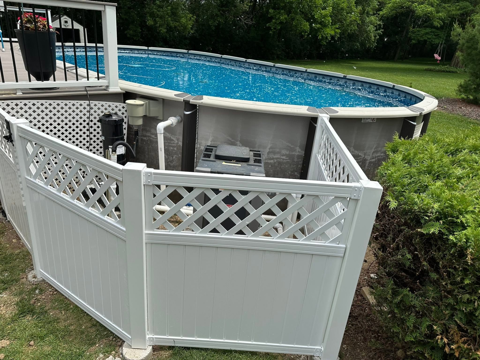 White vinyl privacy enclosure installed around pool equipment