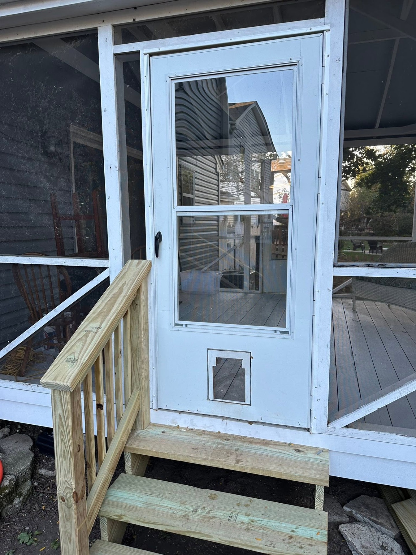 New wood steps and handrail built at a screened porch door