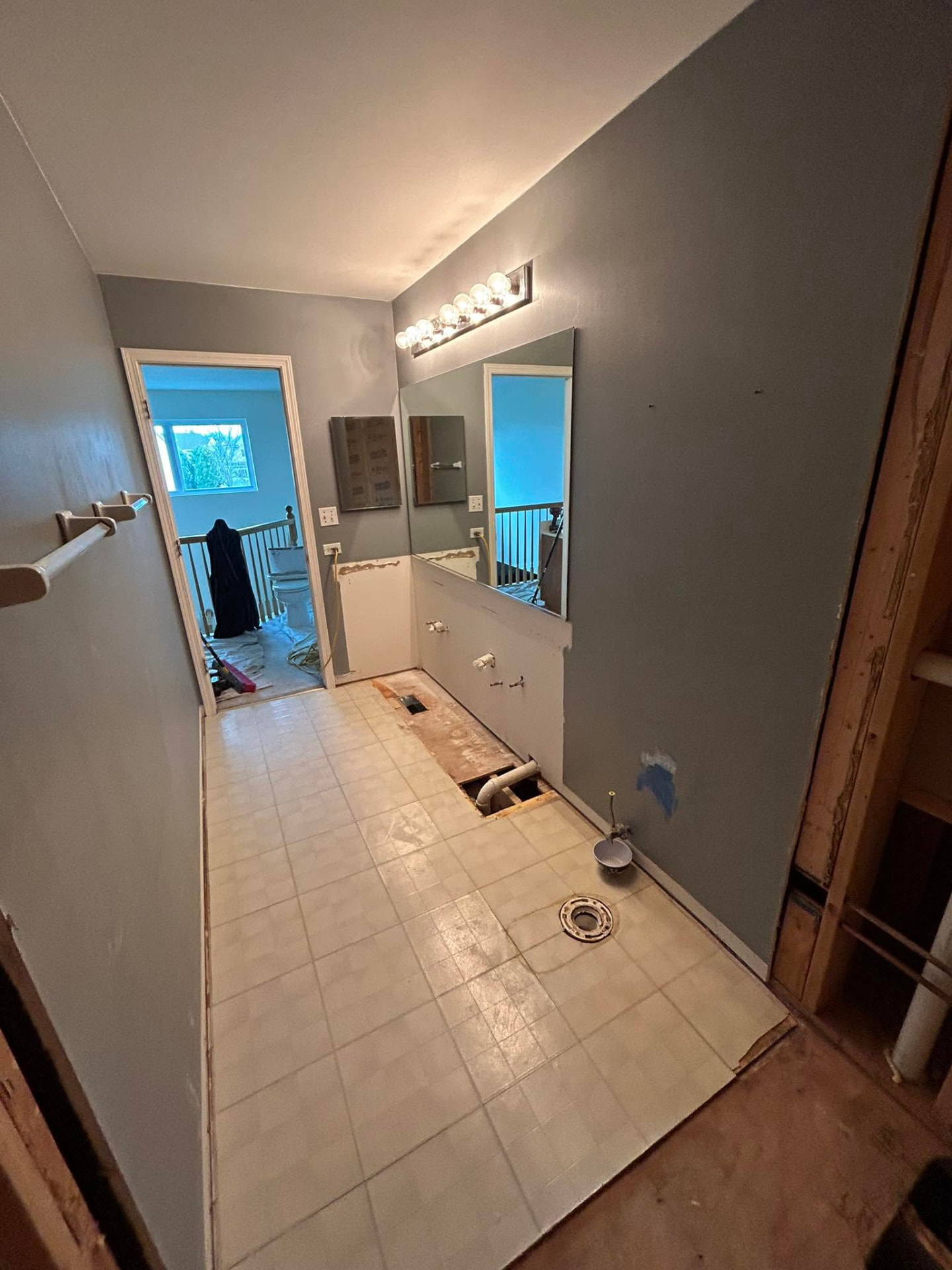 Long bathroom renovation with vanity and wall finishes removed