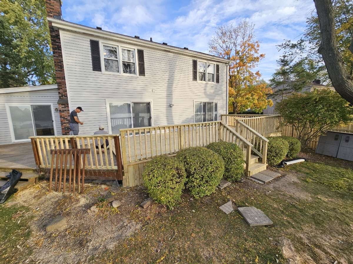 Large backyard deck with new pressure-treated railing and stairs