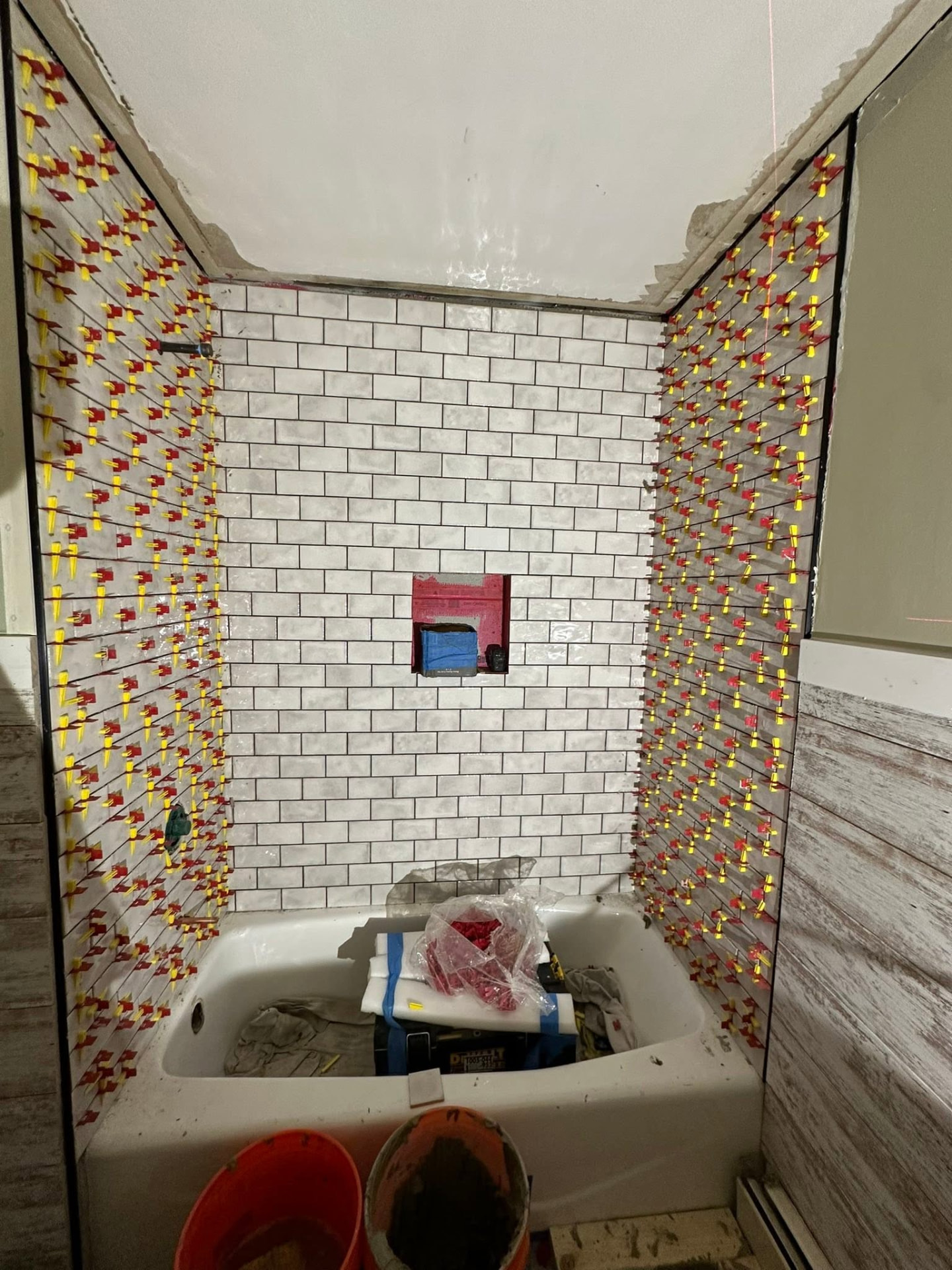 Subway tile installed with leveling clips around a new tub surround