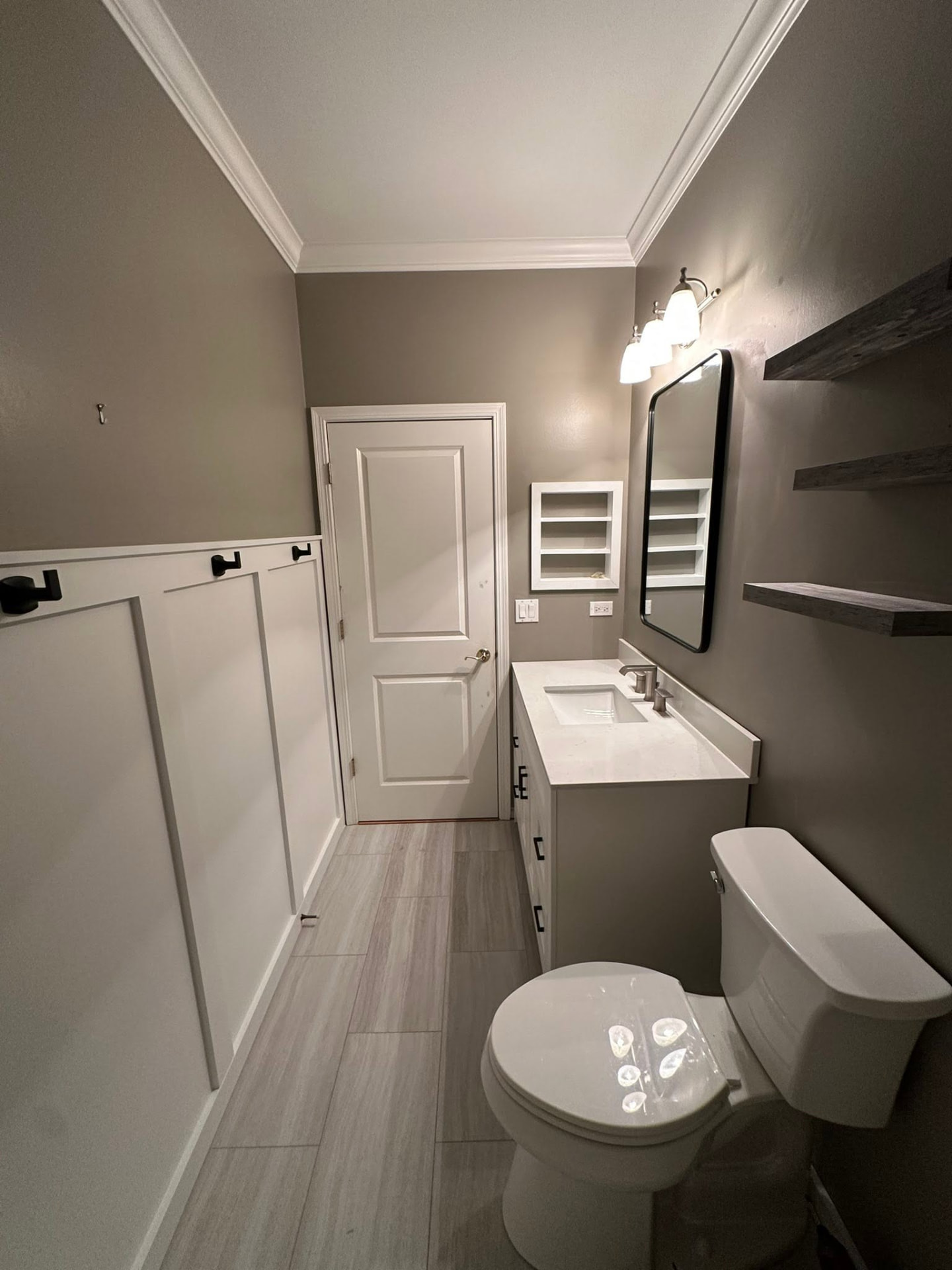 Finished bathroom with board-and-batten wainscoting and quartz vanity